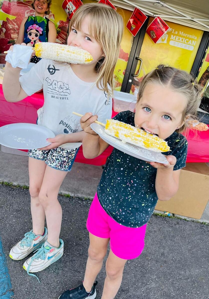 Two girls eating corn on the cob
