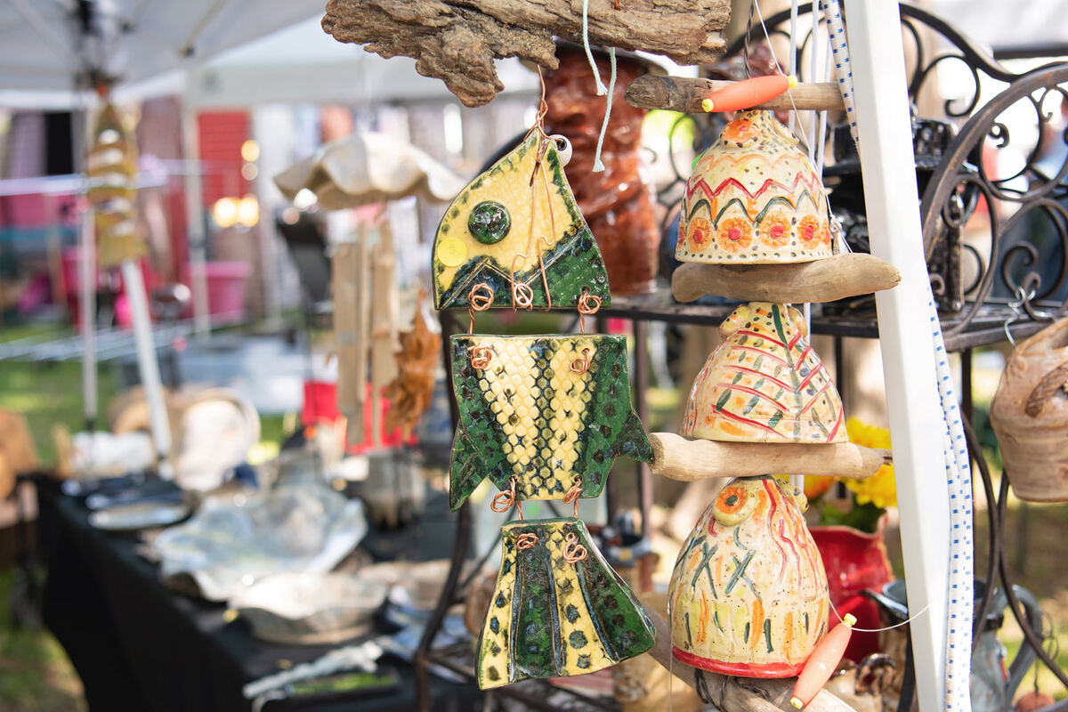 Painted ceramic fish and pottery hanging at a booth